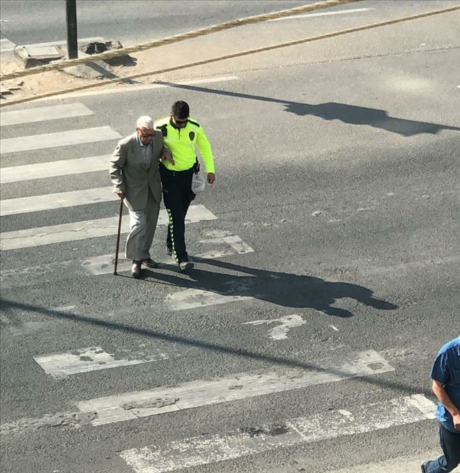 Polis yürümekte zorluk çeken yaşlı adamı kolundan tutarak karşıya geçirdi